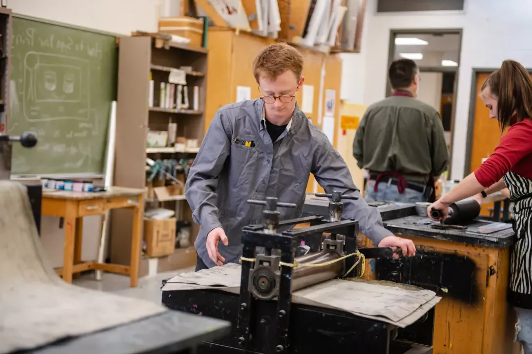 Printmaking student prepares to print his art